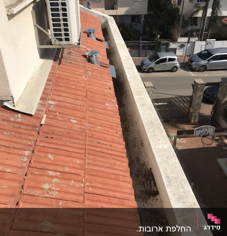 גג רעפים אדום עם מזגן וצינורות אוורור